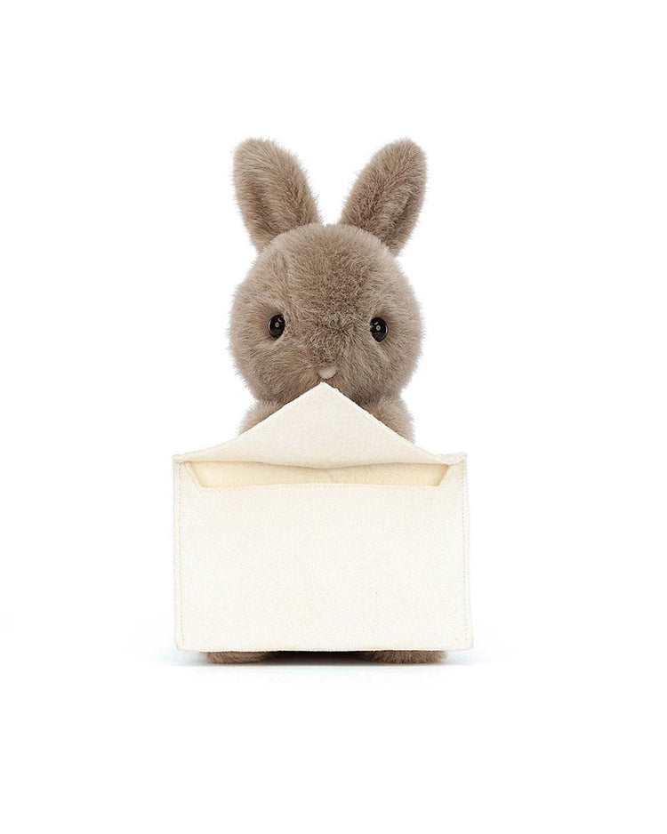 A messenger bunny from Jellycat holds an open envelope in its mouth, ready for a personal message.