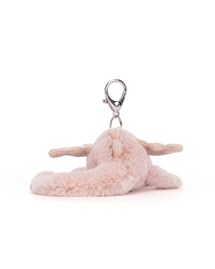 Jellycat's rose dragon bag charm features a plush pink design with floppy ears, glittery wings, and a metal clasp attachment, making it perfect as a charming accessory for your bag.