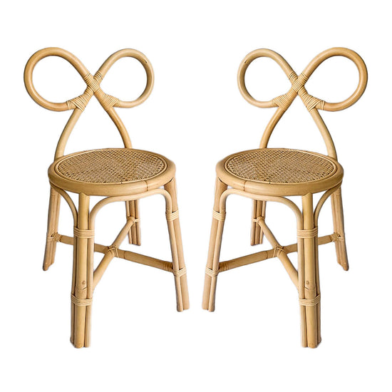 Two Poppie Bow Chairs by poppie toys, featuring looped sculptural backrests and woven cane seats, are displayed side by side against a white background—stylish kids’ chairs for any modern space.