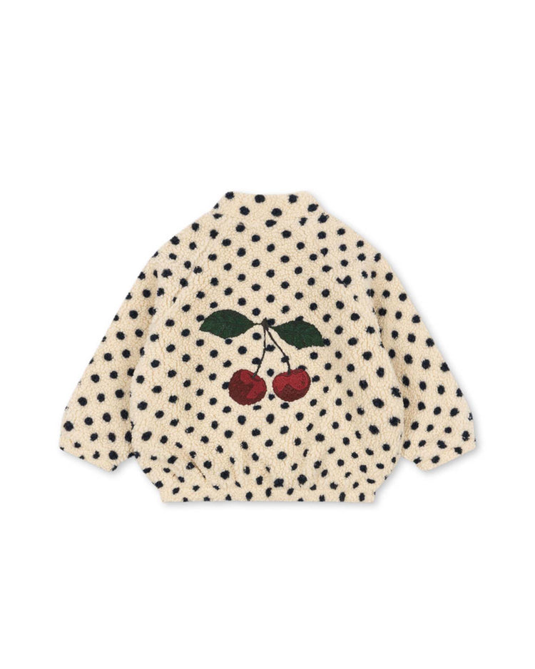 The jody embroidery teddy jacket in dot lumiere by konges sløjd is a cream-colored, long-sleeve pile fleece made from recycled polyester, adorned with black polka dots and finished with a large embroidered cherry graphic with green leaves on the back. OEKO-TEX certified, it is shown against a white background.