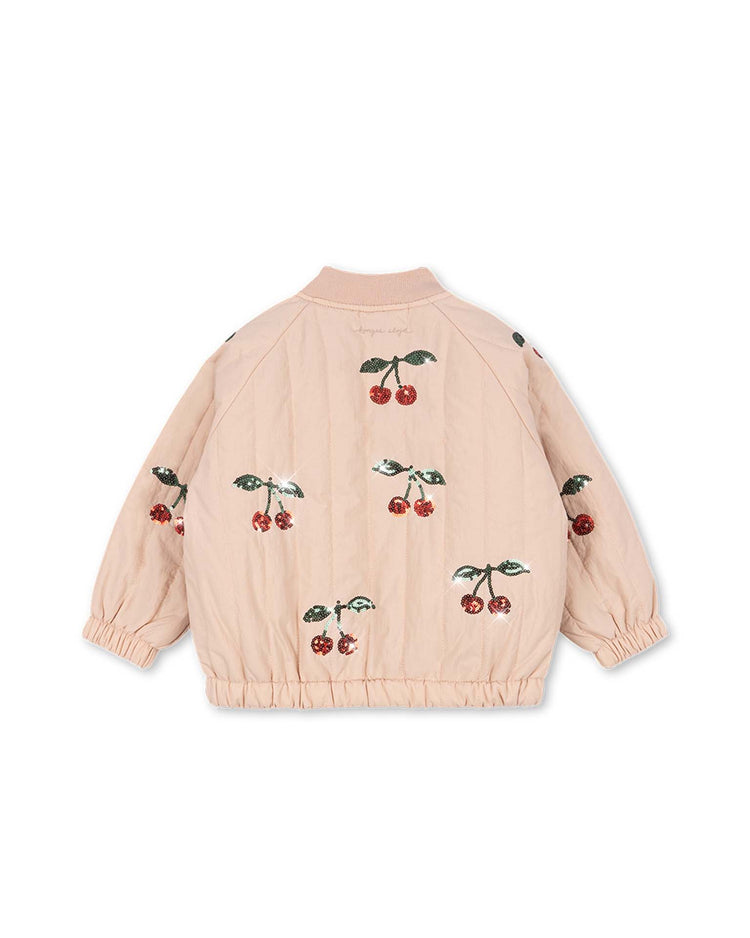 The juno sequin bomber jacket in cameo rose by konges sløjd is a light pink, lightweight outerwear piece featuring elastic cuffs and hem, adorned with embroidered red cherries and green leaves on the back and sleeves.