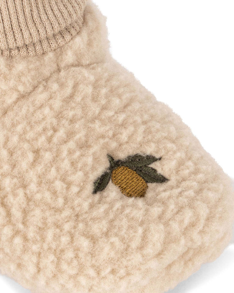 A close-up of the konges sløjd safa boots in oxford tan, crafted from recycled polyester with a ribbed, sock-like ankle and a small embroidered acorn with two green leaves on top.