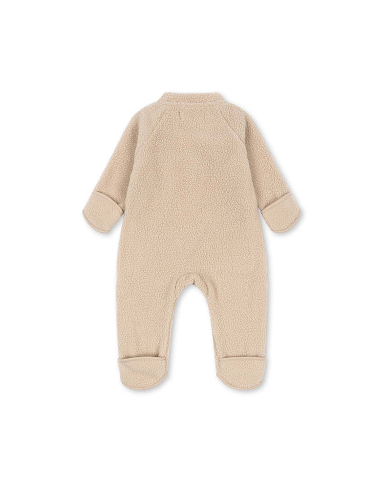 The safa onesie in oxford tan by konges sløjd is a beige baby fleece onesie with long sleeves and covered feet, made from soft recycled polyester. Shown laid flat from the back against a white background, this OEKO-TEX certified onesie ensures comfort and safety for your little one.