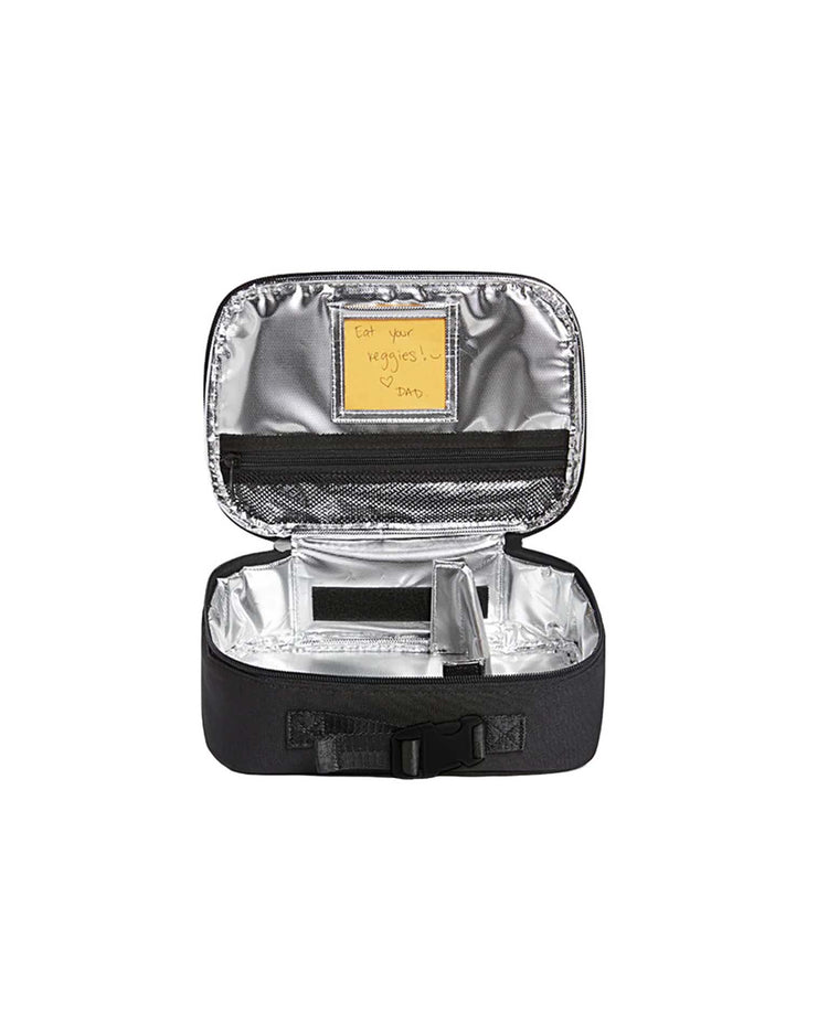 The rodgers lunch box in black by state bags is shown open, revealing a silver, insulated interior with mesh and pocket compartments for storage. A yellow sticky note inside the lid reads “Eat your veggies! – Dad.” This kids lunch box is perfect for keeping snacks fresh all day.