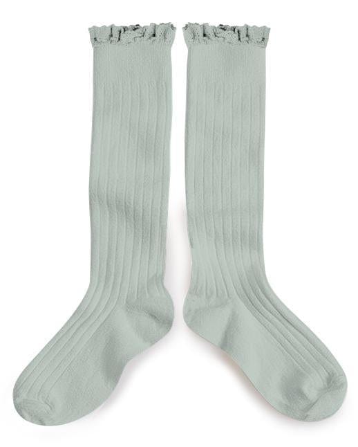 A pair of light green Collegien joséphine knee socks in aigue marine with frayed tops laid against a white background.