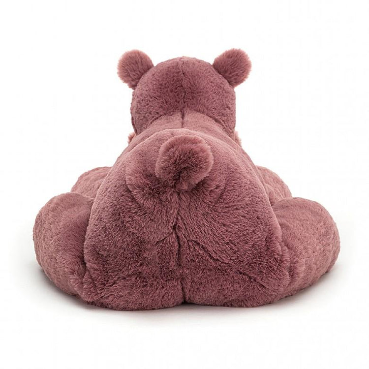 A large-size pink jellycat huggady hippo laying down on a white background.