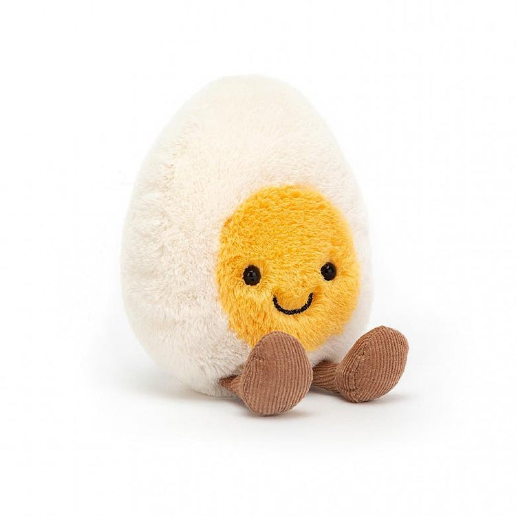 A small happy amuseable boiled egg stuffed animal by Jellycat sitting on a white background.