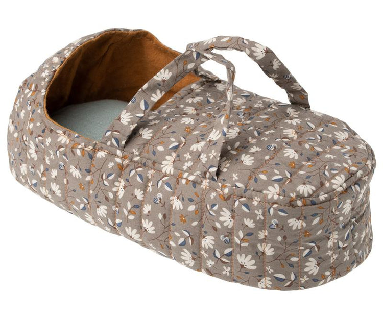A Maileg quilt carry cot in ocher with a floral pattern and a quilted carrycot.
