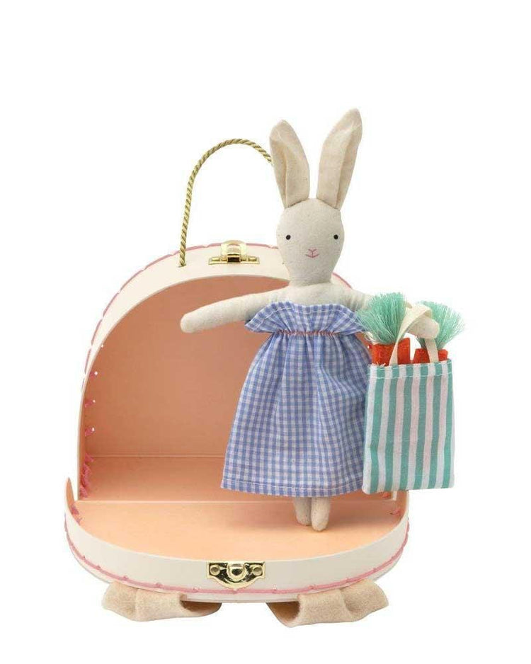 Meri Meri bunny mini suitcase doll in a blue dress sitting inside a pink toy suitcase with a striped carry bag.