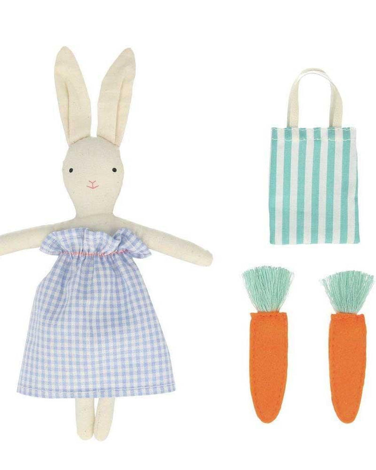 Plush bunny mini suitcase doll with a blue dress, alongside a striped meri meri tote bag and two orange carrot-shaped accessories.