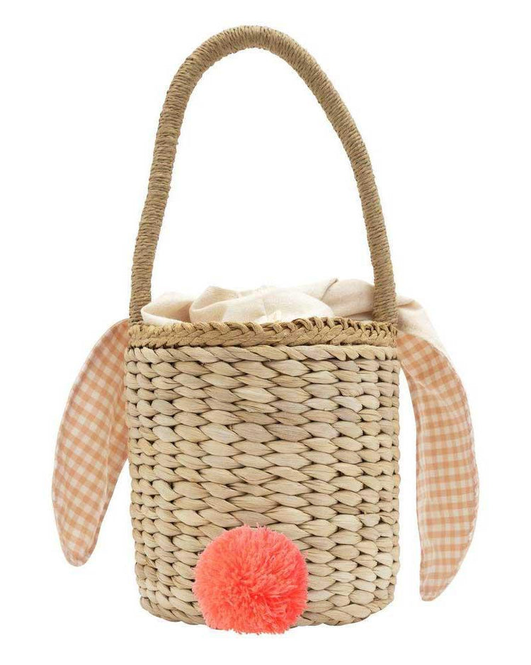 Meri Meri bunny woven straw bag with fabric lining, plaid bunny ears, and a fluffy orange pom-pom tail.