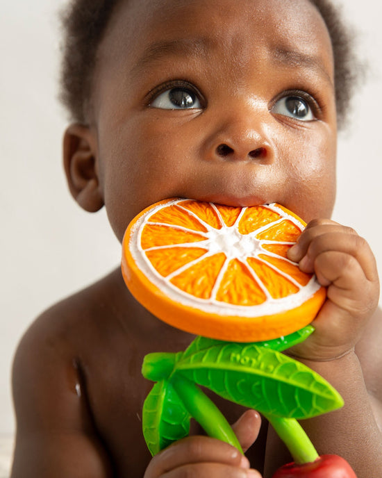 Baby chewing on a clementino the orange teether designed for teething relief by oli + carol.
