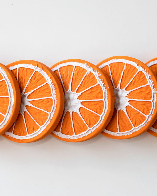 Sliced clementino the oranges in a row with white, frosted edges to support a healthy lifestyle by oli + carol.
