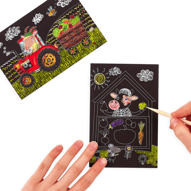 A hand holding a OOLY mini scratch & scribble art kit: farm animals - 7 piece set with a picture of farm animals and a tractor.
