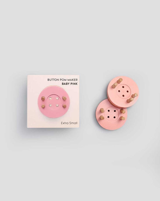 A set of extra small, eco-friendly baby pink pom maker components arranged neatly on a light gray background.