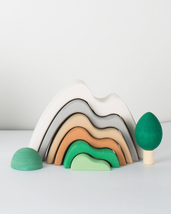 Handmade wooden rainbow stacker toy with raduga grez forest set figures on a white background.