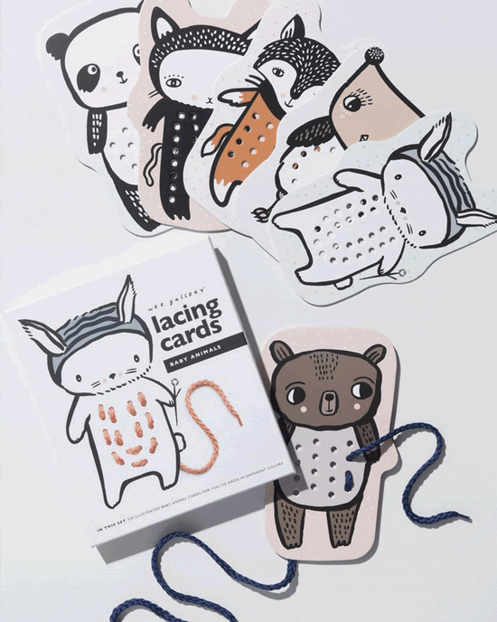 A collection of illustrated baby animals lacing cards from Wee Gallery with a string being threaded through one of the cards.
